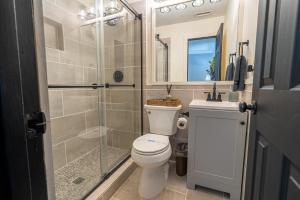 a bathroom with a toilet and a glass shower at New Listing! Boho Mountain Getaway - 2 Bed, 2 Bath in Dahlonega