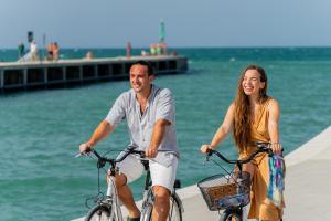 un hombre y una mujer montando bicicletas junto al agua en Piccolo Hotel, en Bellaria-Igea Marina
