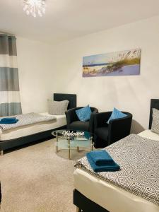 ガルプセンにあるKriDa Comfort Ferienwohnungのベッド2台、ソファ、テーブルが備わる客室です。