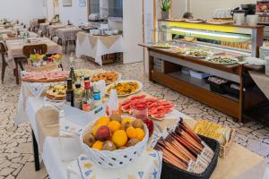 una línea de buffet con platos de comida en un restaurante en Piccolo Hotel, en Bellaria-Igea Marina