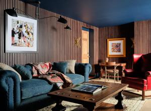 a living room with a blue couch and a table at The Hotel Portsmouth - Downtown in Portsmouth +27 photos
