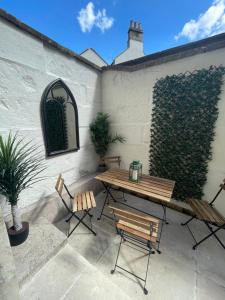 a patio with a wooden table and two chairs at Stylish period maisonette flat in centre of Bath in Bath