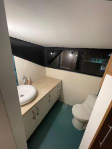 La salle de bains est pourvue d'un lavabo blanc et de toilettes. dans l'établissement Casa 5 habitaciones bonitas y elegante, à Puerto Baquerizo Moreno