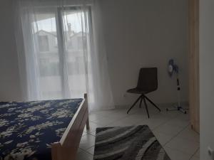 耶爾薩的住宿－Apartmani Miletić，卧室配有床、椅子和窗户。