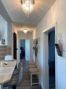 a room with a table and chairs and a chandelier at -Fewo Benz- Exklusive Ferienwohnung im Stadtzentrum von Wittenberge Modernes Ambiente, 3 Einzelzimmer für bis zu 6 Gäste - voll ausgestattet mit Waipu-TV und High-Speed-WLAN Bettwäsche und Handtücher inklusive! in Wittenberge