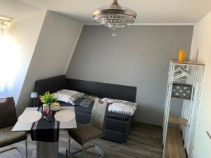 a living room with a couch and a table at -Fewo Benz- Exklusive Ferienwohnung im Stadtzentrum von Wittenberge Modernes Ambiente, 3 Einzelzimmer für bis zu 6 Gäste - voll ausgestattet mit Waipu-TV und High-Speed-WLAN Bettwäsche und Handtücher inklusive! in Wittenberge +23 photos