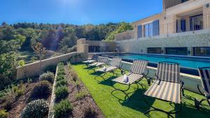 un grupo de sillas sentadas en un césped junto a una piscina en Mas La Rose Sauvage - magnificent Luberon views, en Murs 70 fotos más