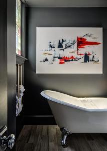 樸茨茅斯的住宿－朴茨茅斯市中心酒店，带浴缸的浴室,墙上有绘画作品