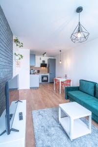 a living room with a green couch and a table at Verde Apartment SelfCheck-in 24h in Wrocław
