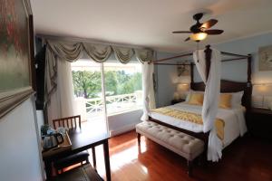 a bedroom with a canopy bed and a window at Lipton Place by Elegant Waterfront in Victoria