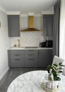una cocina con armarios grises y una mesa con una planta en Apartment Hartenrod en Bad Endbach
