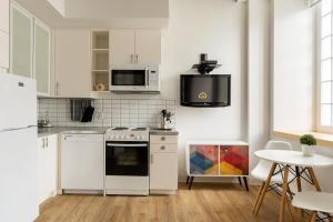 a white kitchen with a stove and a microwave at Les Lofts de Buade - Par Les Lofts Vieux-Québec in Quebec City