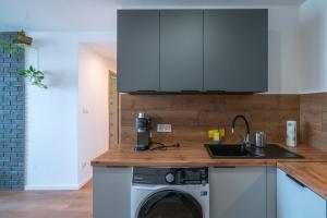 a kitchen with a sink and a washing machine at Verde Apartment SelfCheck-in 24h in Wrocław +1 photo