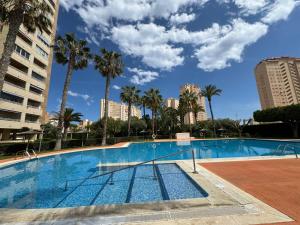 a swimming pool with palm trees and buildings at Natura playa By Sunset in La Venteta