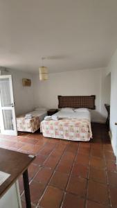 um quarto com 2 camas e piso em azulejo em Hotel Camboa Antonina - PR em Antonina