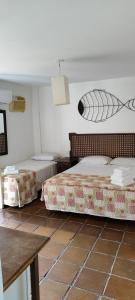 a room with two beds and a table at Hotel Camboa Antonina - PR in Antonina
