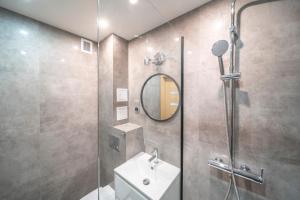 a bathroom with a shower with a sink and a mirror at Verde Apartment SelfCheck-in 24h in Wrocław