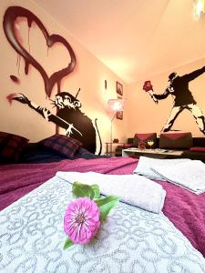 ein Schlafzimmer mit einem Bett mit einer Blume darauf in der Unterkunft "Banksy" Art in Warschau