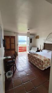 um quarto com uma cama, uma secretária e uma janela em Hotel Camboa Antonina - PR em Antonina