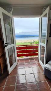 uma porta aberta para uma varanda com vista para o oceano em Hotel Camboa Antonina - PR em Antonina