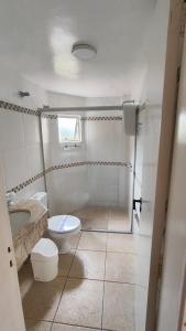 uma casa de banho branca com um WC e um lavatório em Hotel Camboa Antonina - PR em Antonina