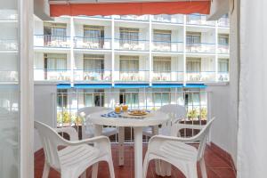 een balkon met een tafel en stoelen en een gebouw bij Apartamento en Tossa de Mar a 3 min de la playa in Tossa de Mar