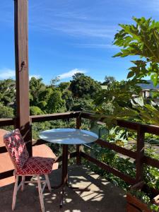 a table and a chair on a balcony with a view at Vibe House Hostel in Florianópolis