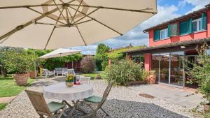 a patio with a table and an umbrella at Casa Rocchi in Capannori