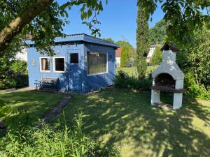 a blue shed with a stove in a yard at Ferienwohnung Angela in Neuenkirchen