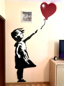 Ein Junge mit einem Ballon-Wandsticker. in der Unterkunft "Banksy" Art in Warschau