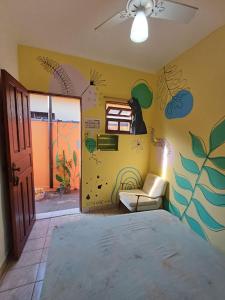 a room with a bed and a room with a painting on the wall at Hostel do Valdemar in Praia Grande