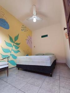 a bedroom with a bed in the corner of a room at Hostel do Valdemar in Praia Grande