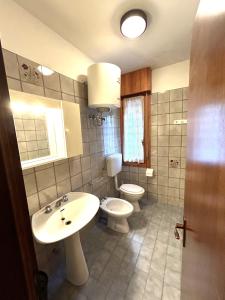 ビビオーネにあるCondominio Sabrina Lido del Soleの洗面台とトイレ付きのバスルーム