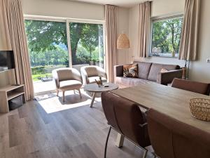 uma sala de estar com uma mesa e um sofá em Domein Hellebeuk met UITZICHT! Valkenburg/Klimmen em Klimmen
