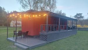 a red cabin with a table and chairs on a deck at Pids randõ in Kolka