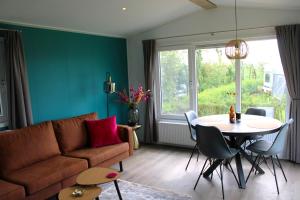 uma sala de estar com um sofá e uma mesa em Minicamping Zonnehoek em Biggekerke