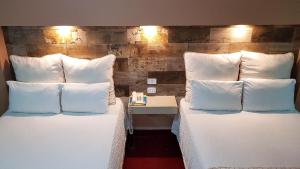 2 camas en una habitación de hotel con almohadas blancas en Hotel Royal Inn, en Monclova