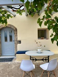 Elia Houses - Traditional House With Backyard في Kastrisiánika: طاولة وكراسي أمام باب