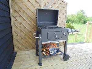 a barbecue grill on a cart on a deck at The Cabin in Pakenham