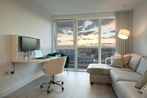 豪士罗Sunset Retreat: Steps from Heathrow/Twickenham的客厅配有书桌、电脑和沙发
