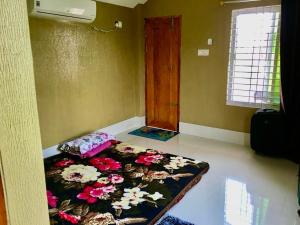 una camera con un letto fiorito sul pavimento di Wahidul House a Rajshahi