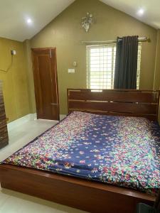 a bedroom with a large bed with a colorful blanket at Wahidul House in Rājshāhi