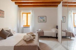 Habitación blanca con 2 camas y toallas en un sofá en Arena Apartment Verona, en Verona
