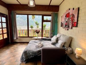 een slaapkamer met een bed en een groot raam bij Bubucoca Residence in Baños