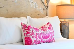 ein rosa Kissen auf einem Bett mit weißen Kissen in der Unterkunft Tesuque Outpost Casita F Mountain Views in Santa Fe