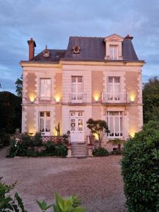 a large house with lights on the front of it at LA MAISON LEONARD in Bléré