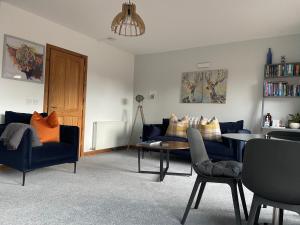 uma sala de estar com um sofá, uma mesa e cadeiras em Thistle Do Fort William em Fort William