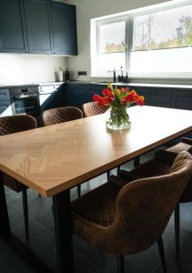 una mesa de cocina con un jarrón de flores. en Private House with 4 Bedrooms and SAUNA near TARTU, 