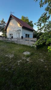 een wit huis met een hek ervoor bij Agroturystyka Kluki u Tosi in Smołdzino