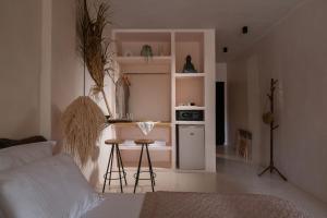 a living room with a couch and a kitchen with a counter at Kynthia Hotel - Adults Only in Kalogria